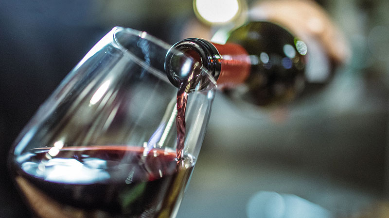 garrafa a servir copo de vinho tinto